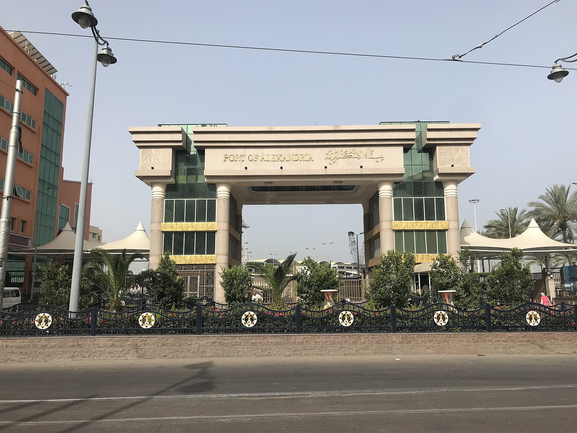 The stone entrance gate of the Port of Alexandria in Egypt, with port cranes visible behind it