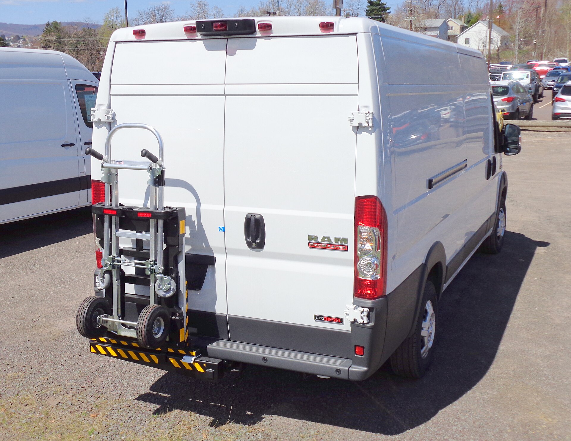 A white cargo delivery van fitted with a loading dolly, ready for distribution